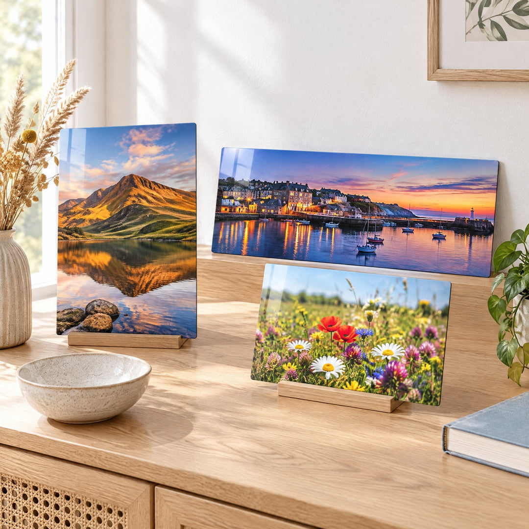 Sublimation rectangle panels: photo panels of a mountain lake, a harbour town at sunset and a wildflower meadow, standing in wooden blocks on a sideboard
