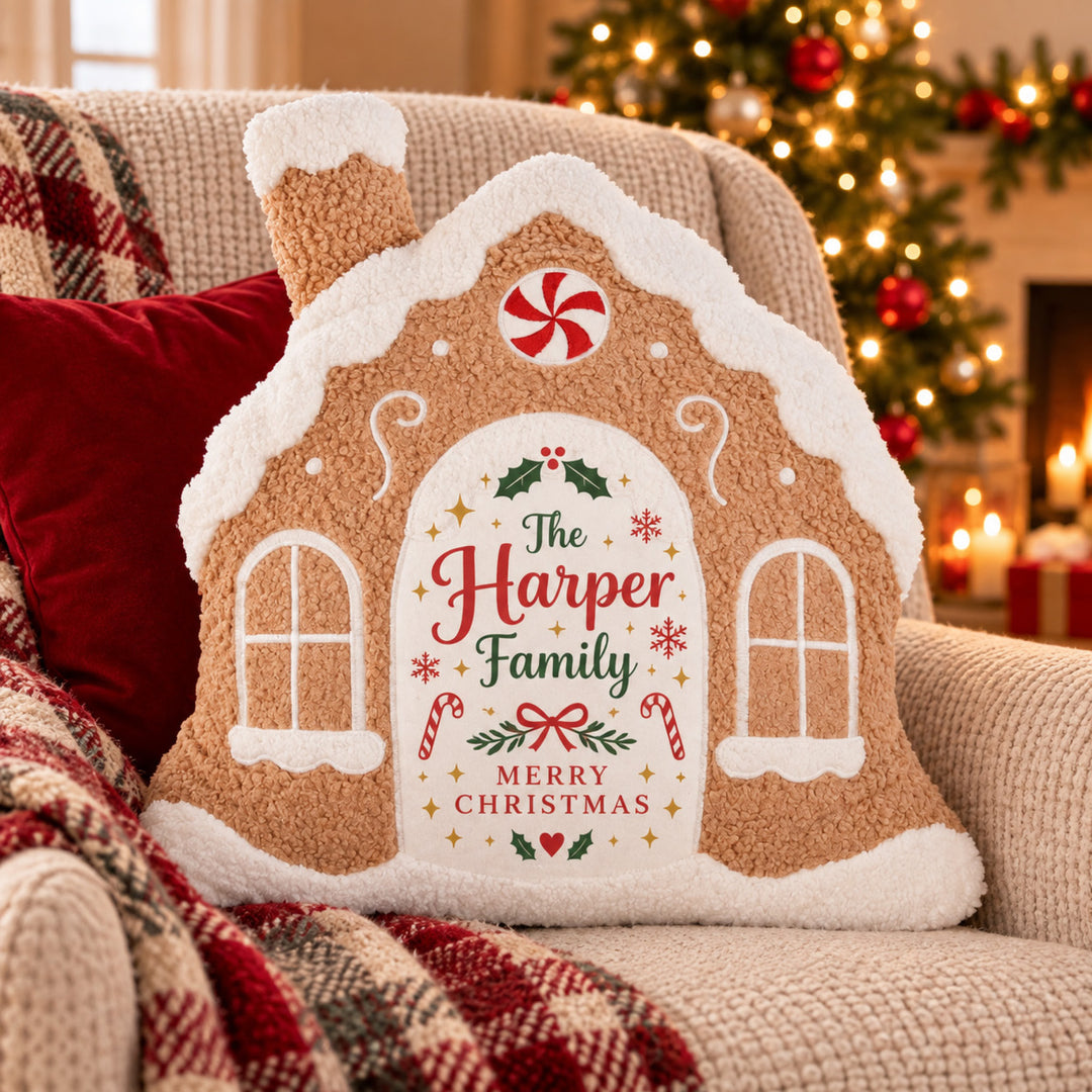 Personalised Gingerbread House cushion with "The Harper Family Merry Christmas" design on an armchair 