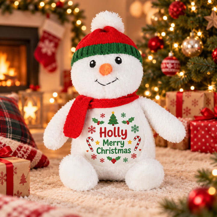Personalised Snowman plush toy with "Holly Merry Christmas" design, sitting by a Christmas tree