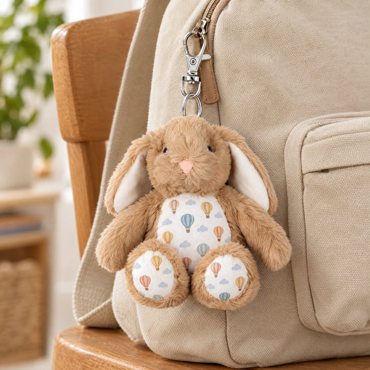 Sublimation brown rabbit plush keyring printed with hot-air balloons, clipped to a canvas backpack