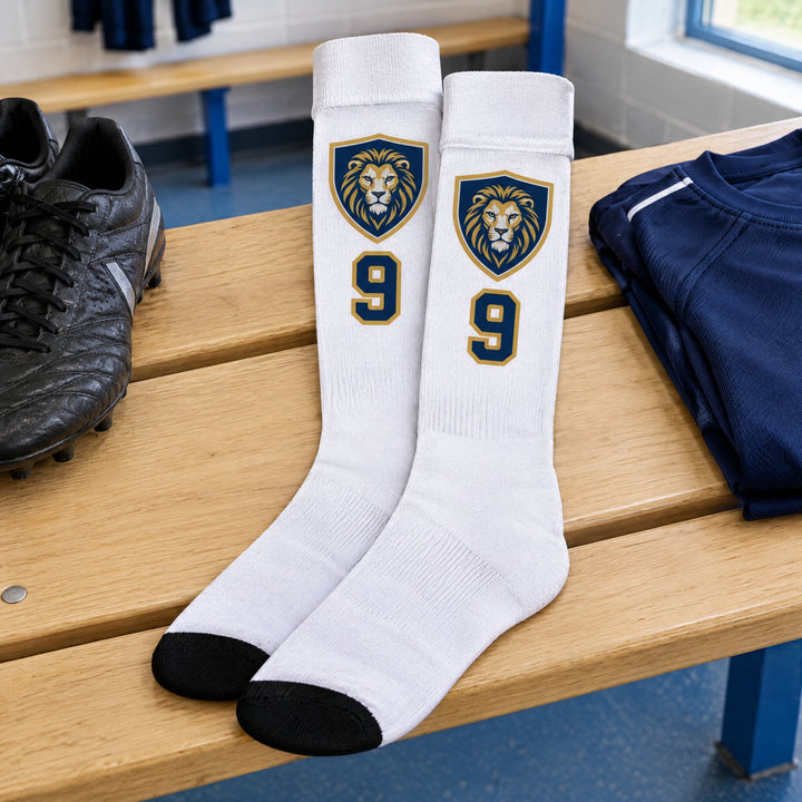Sublimation football socks printed with an illustrated club crest, lying on a wooden bench