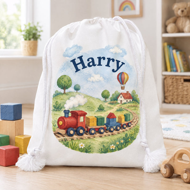 White cotton drawstring bag 25 x 30cm printed with a watercolour storybook scene and the name Harry, on a wood nursery floor